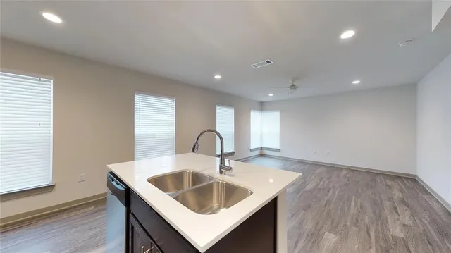 a close view of a sink and dishwasher with wooden floor