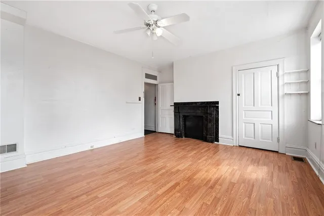 a view of empty room with wooden floor and fireplace