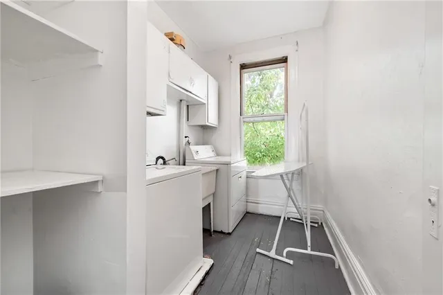 a room with white cabinets and a wooden floor