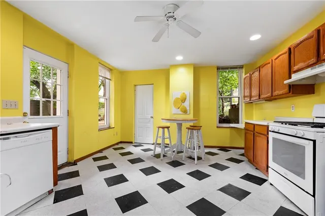 a view of a kitchen with a stove a sink and a window
