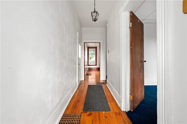 a view of a hallway with wooden floor and a hallway