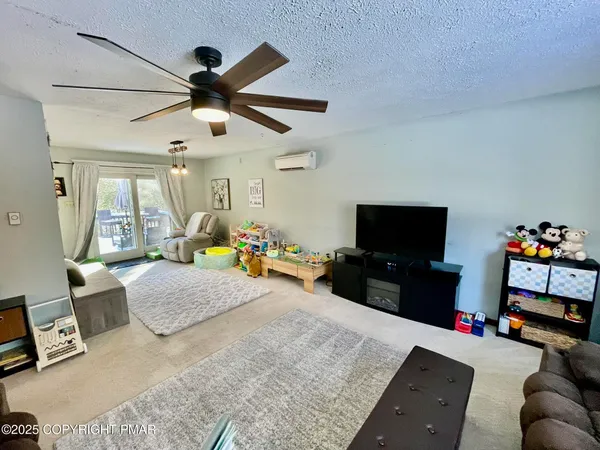 a living room with furniture a flat screen tv and a dining table
