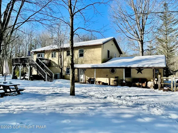 a view of a house with backyard and sitting area