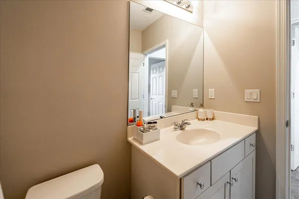 a bathroom with a sink a toilet and mirror
