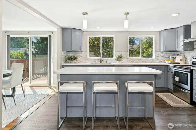 a kitchen with a stove a sink and chairs