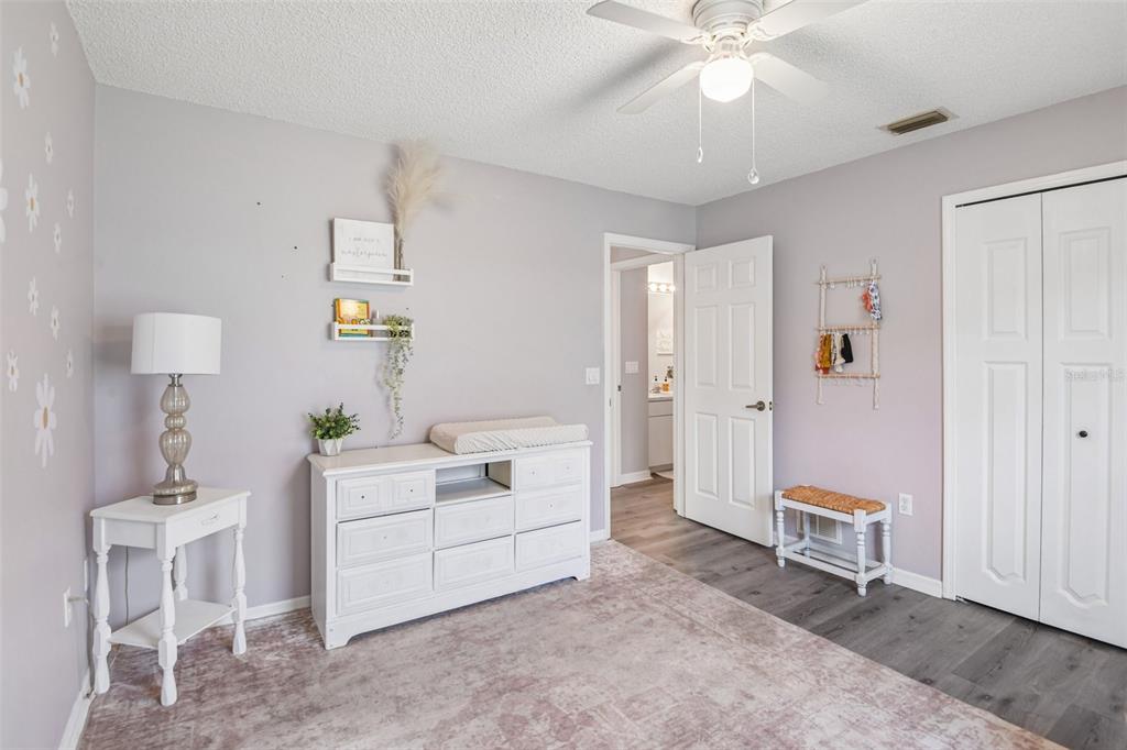 1129 Daleside Lane New Port Richey, FL 34655 - Photo 23 of 34 a spacious bedroom with a bed and a chandelier