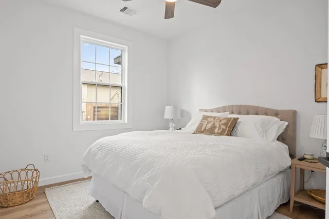 a large bed sitting in a bedroom next to a window and a chair