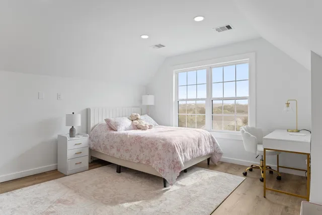 a bedroom with a bed and a large window