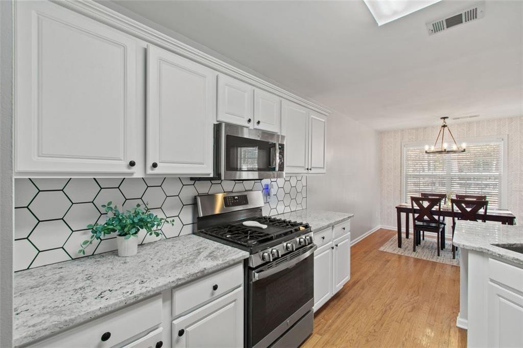 2907 Albright Commons Kennesaw, GA 30144 - Photo 7 of 35 a kitchen with granite countertop a sink stove and cabinets