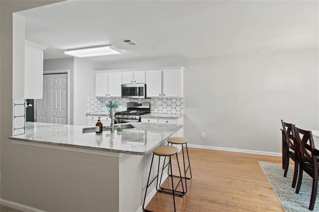 2907 Albright Commons Kennesaw, GA 30144 - Photo 10 of 35 a kitchen with a table chairs microwave and cabinets
