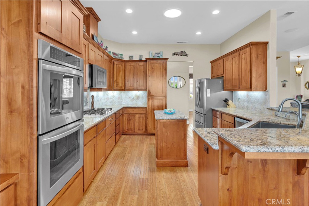 654 Red Cloud Road Paso Robles, CA 93446 - Photo 14 of 46 a kitchen with stainless steel appliances granite countertop a sink a stove top oven a counter space and cabinets