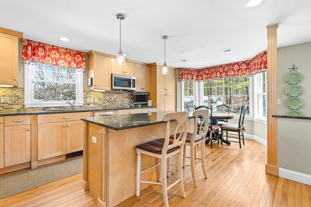24 Cider Mill Road Framingham, MA 01701 - Photo 6 of 19 a kitchen with stainless steel appliances granite countertop wooden floor window and chairs
