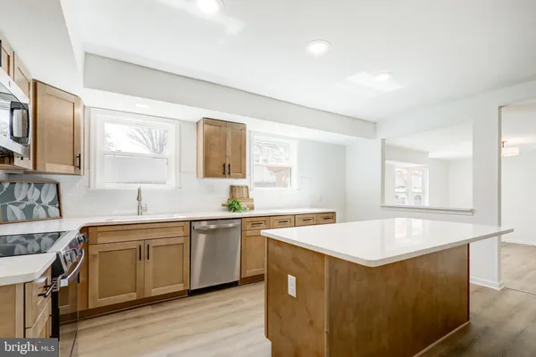 a view of a kitchen counter space a sink wooden floor and a window
