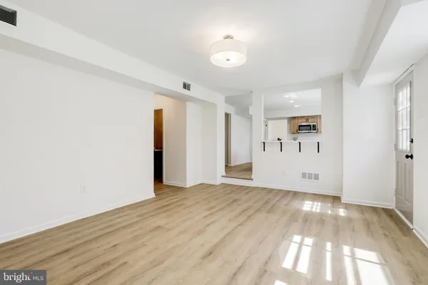 a view of empty room with wooden floor