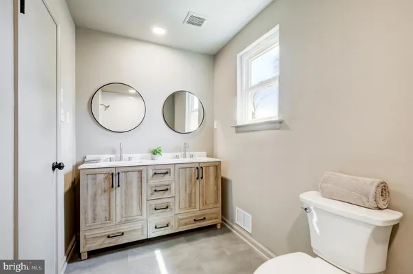 a spacious bathroom with a toilet sink and mirror