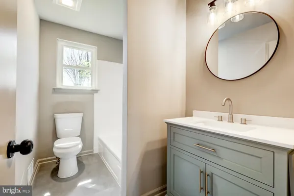 a bathroom with a toilet a sink and a mirror