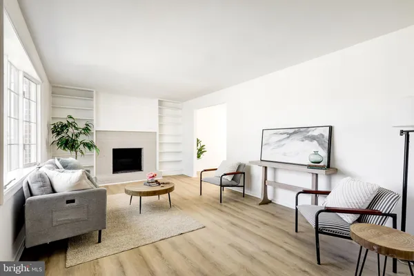 a living room with furniture a fireplace and a potted plant
