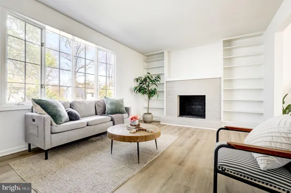a living room with furniture a fireplace and a large window