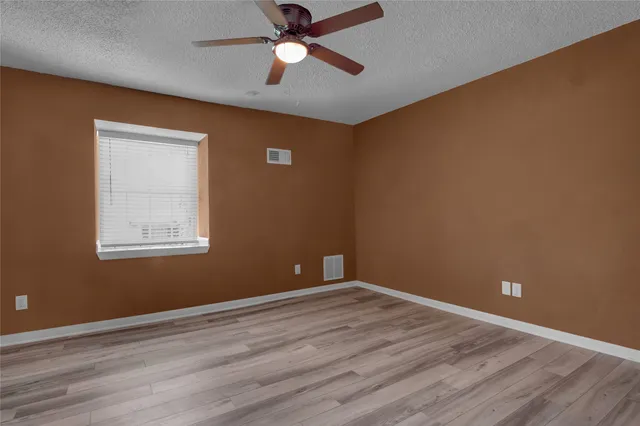 a view of room with wooden floor and fan