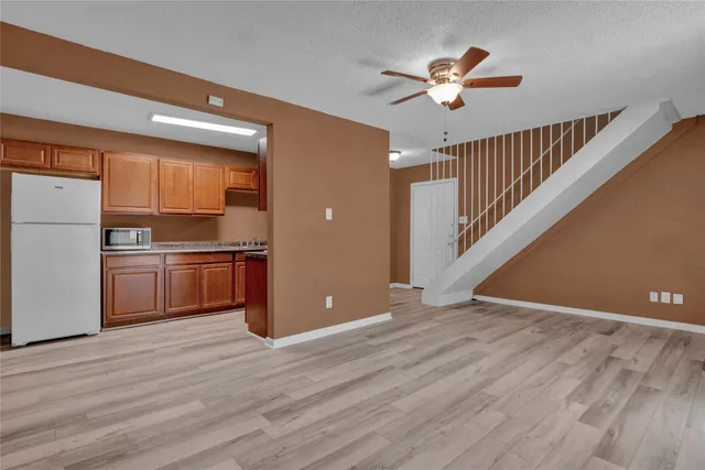 a view of a kitchen with a ceiling fan and wooden floor