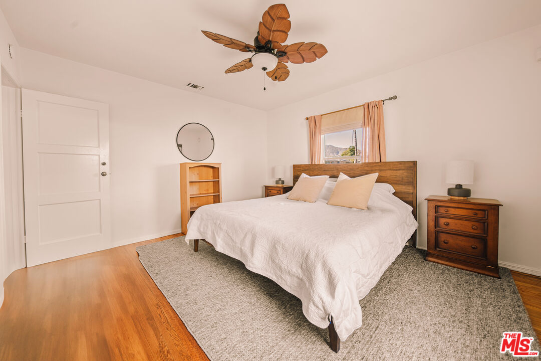 592 Figueroa Drive Altadena, CA 91001 - Photo 11 of 19 a bedroom with a bed and dresser with wooden floor