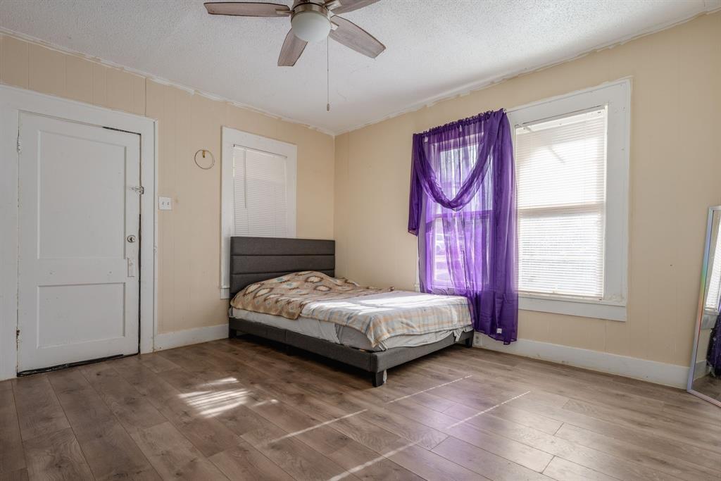514 Pierce Street Denton, TX 76201 - Photo 13 of 18 a bedroom with a bed and a chandelier
