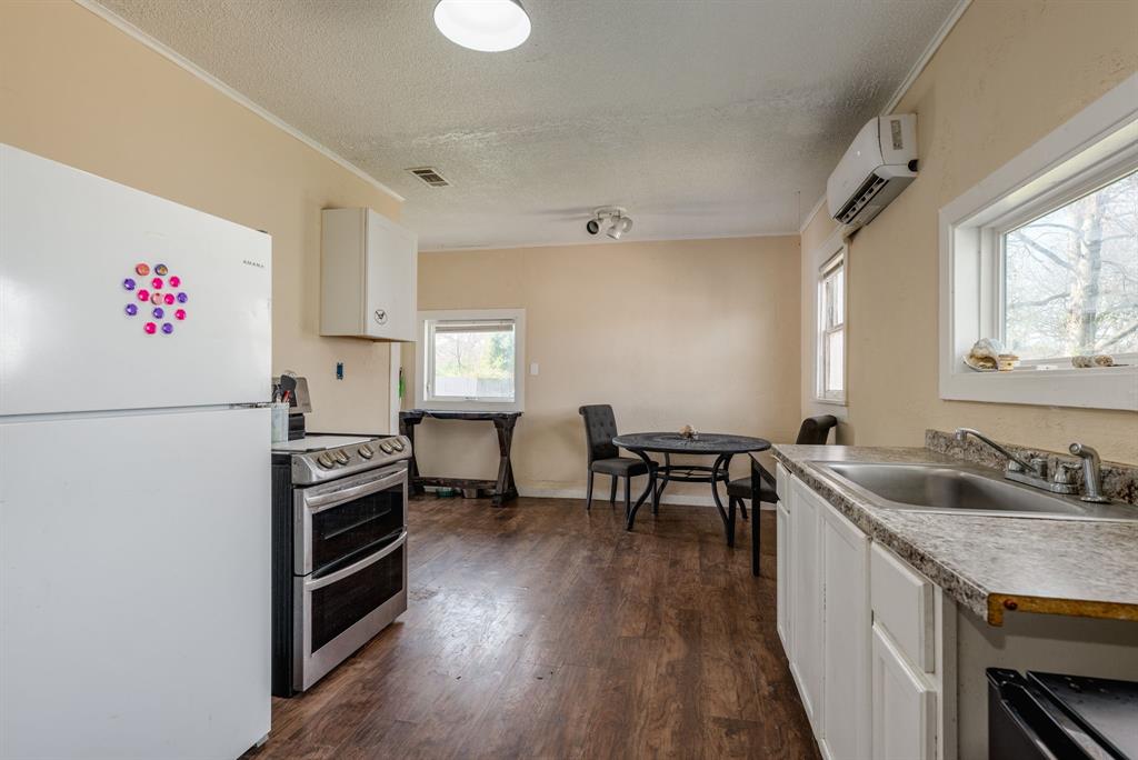 514 Pierce Street Denton, TX 76201 - Photo 6 of 18 a kitchen with granite countertop a sink stove and refrigerator