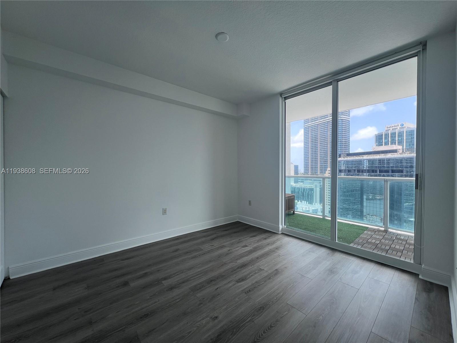 1250 South Miami Avenue, Unit 2104 Miami, FL 33130 - Photo 12 of 18 an empty room with wooden floor and windows