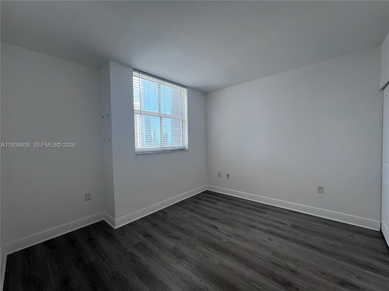 1250 South Miami Avenue, Unit 2104 Miami, FL 33130 - Photo 17 of 18 a view of an empty room with wooden floor and a window
