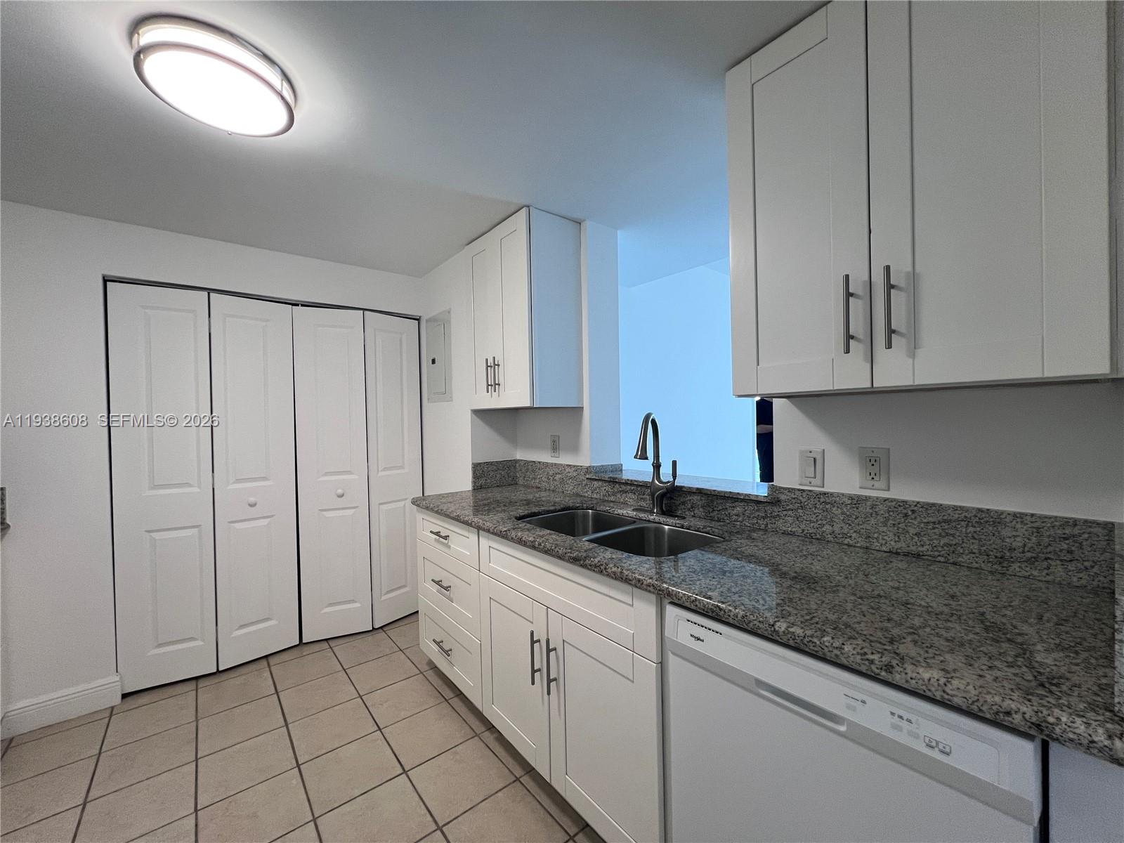 1250 South Miami Avenue, Unit 2104 Miami, FL 33130 - Photo 5 of 18 a kitchen with granite countertop white cabinets and sink