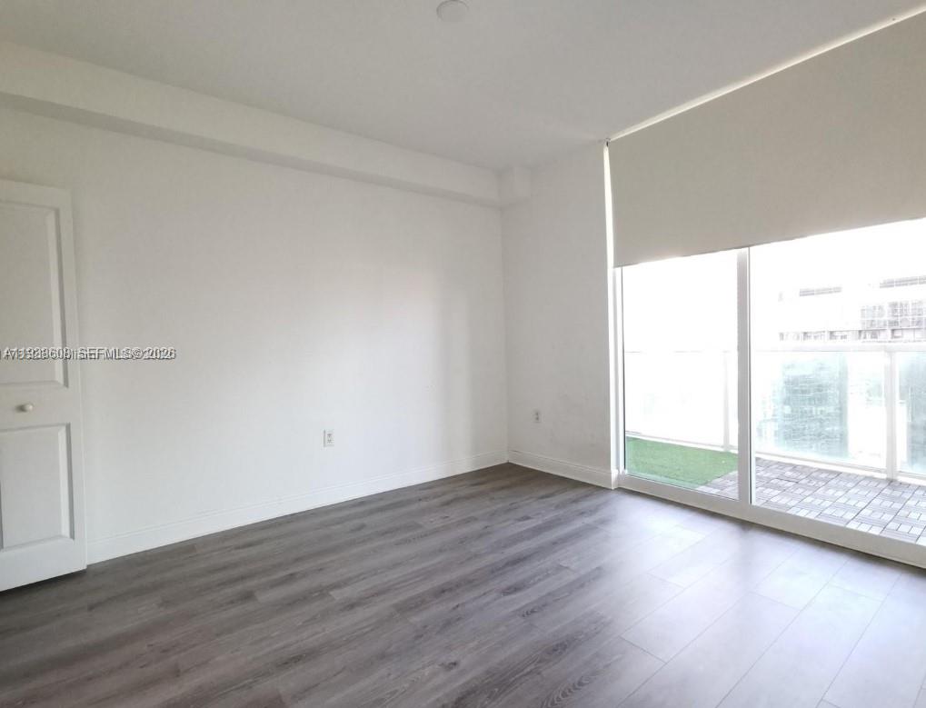 1250 South Miami Avenue, Unit 2104 Miami, FL 33130 - Photo 8 of 18 an empty room with wooden floor and windows