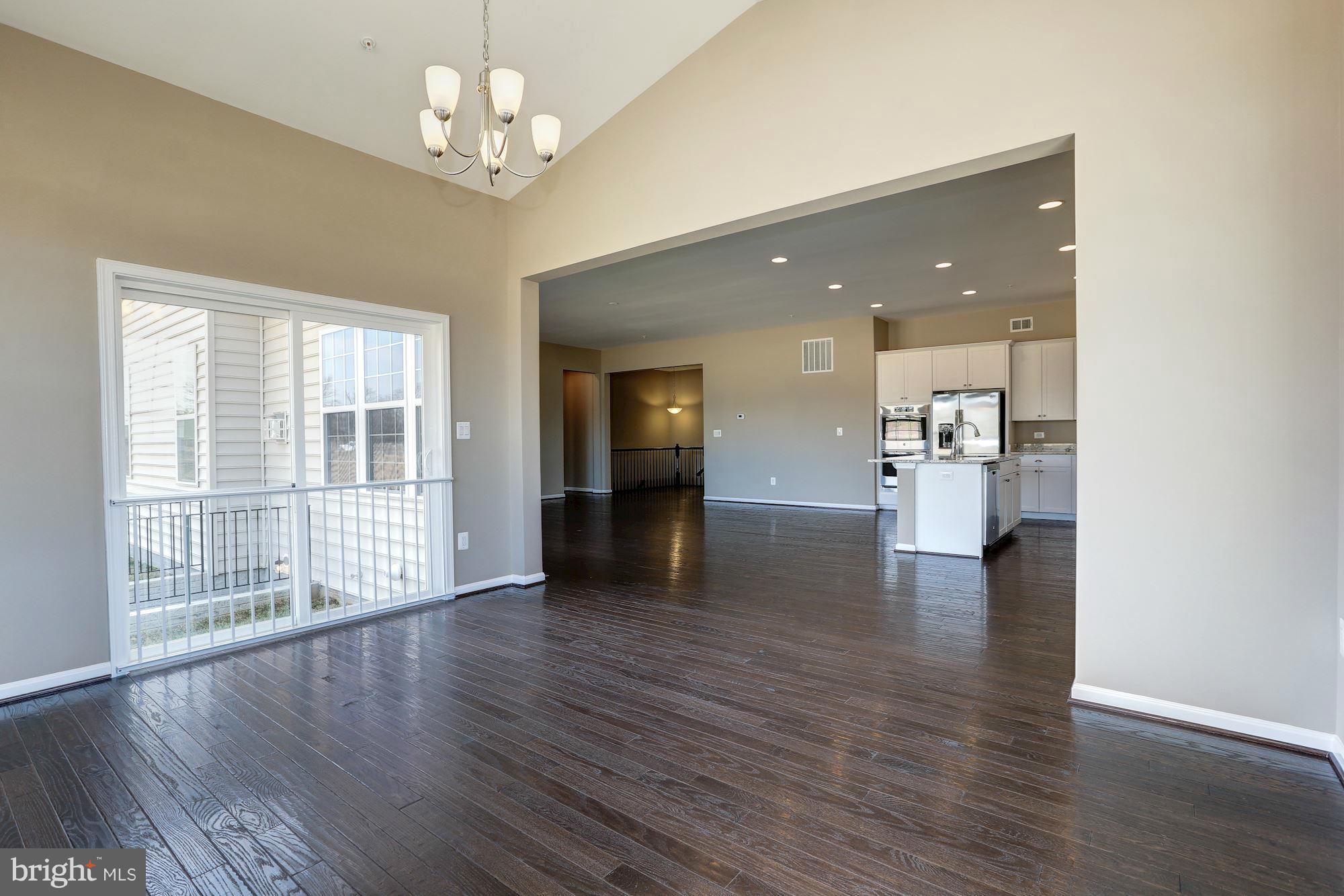 925 Lindley Road Frederick, MD 21701 - Photo 14 of 30 a view of an empty room with wooden floor and a kitchen