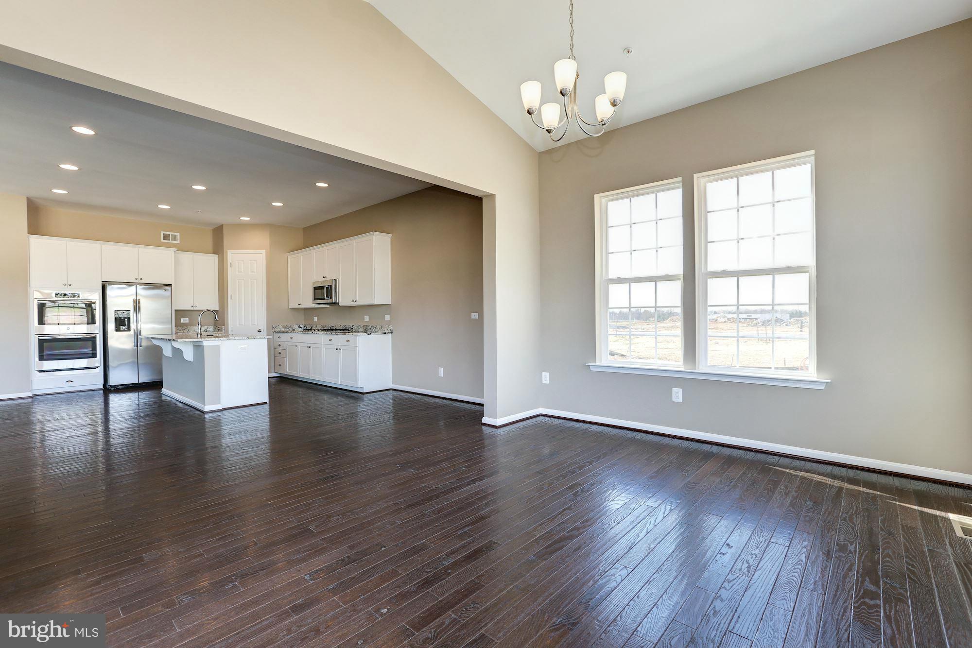 925 Lindley Road Frederick, MD 21701 - Photo 15 of 30 a view of an empty room with wooden floor and kitchen view