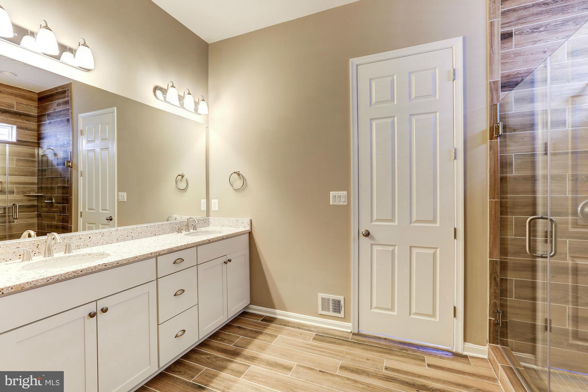 925 Lindley Road Frederick, MD 21701 - Photo 18 of 30 a spacious bathroom with a double vanity sink a mirror and a shower