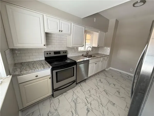 a kitchen with a stove sink and cabinets