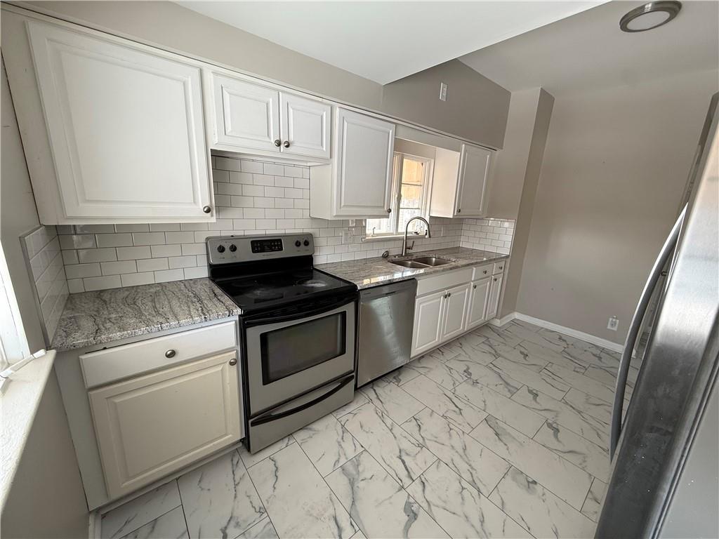 1056 Adams Street New Castle, PA 16101 - Photo 4 of 10 a kitchen with a stove sink and cabinets