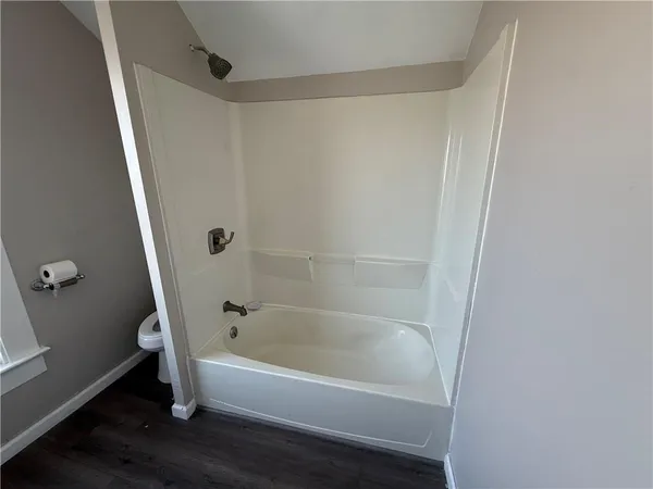a white bath tub sitting next to a white sink and vanity