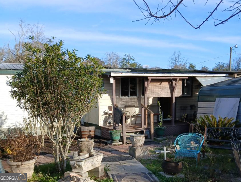 309 Sunset Lane Cairo, GA 39828 - Photo 1 of 6 a view of a patio with table and chairs potted plants and large tree