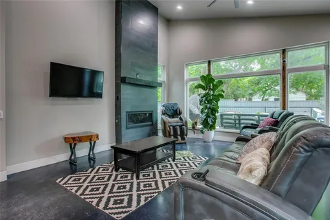 a living room with furniture a flat screen tv and a large window