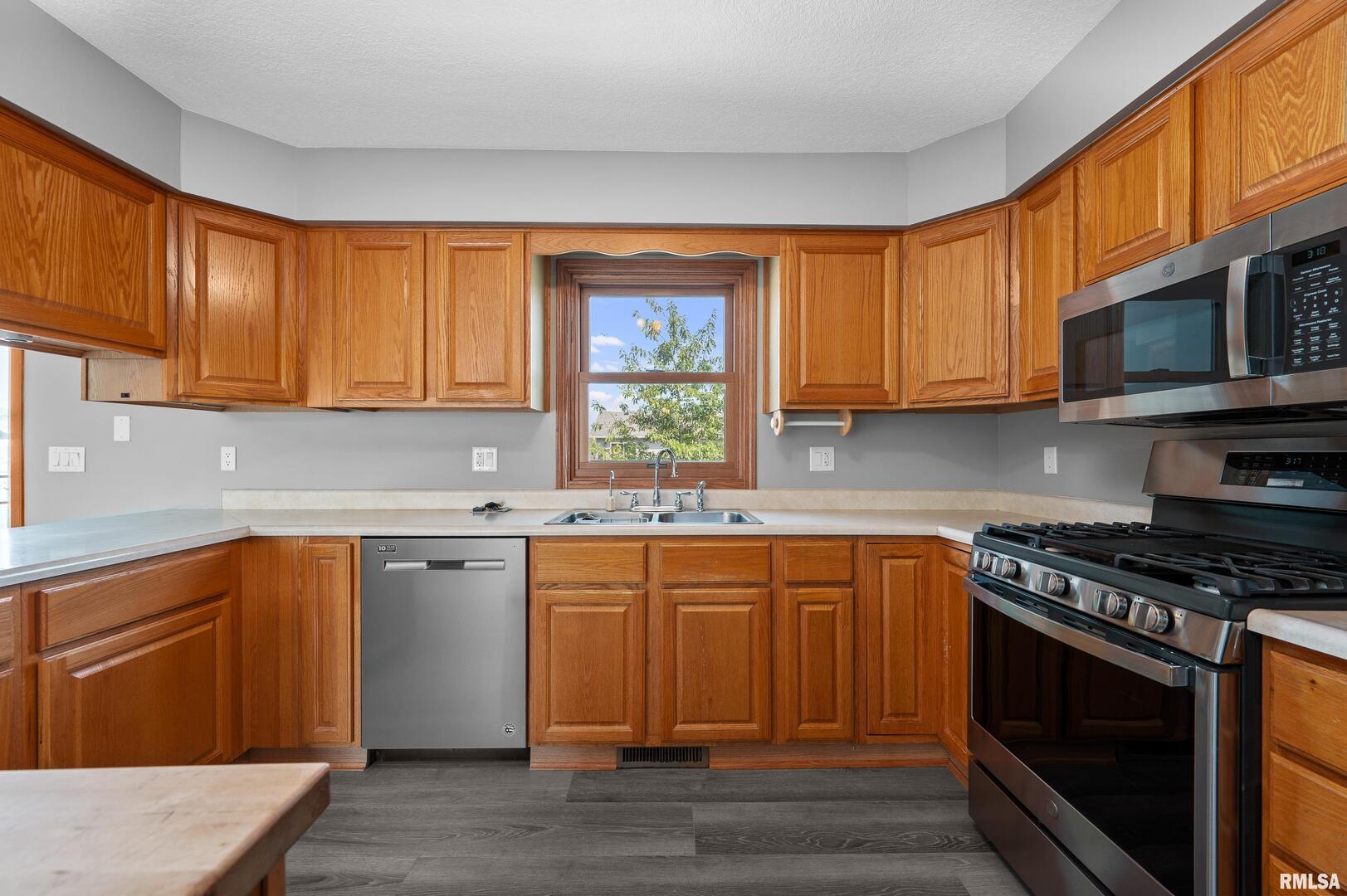 916 Ash Drive Colona, IL 61241 - Photo 12 of 38 a kitchen with stainless steel appliances granite countertop a stove a sink and a microwave