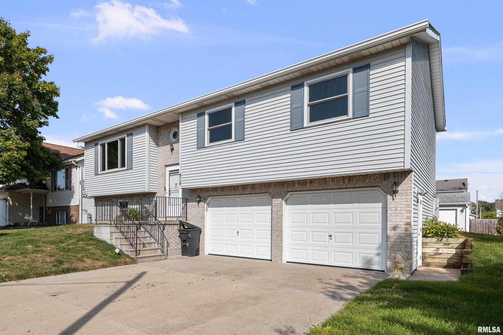 916 Ash Drive Colona, IL 61241 - Photo 2 of 38 a front view of a house with a yard and garage