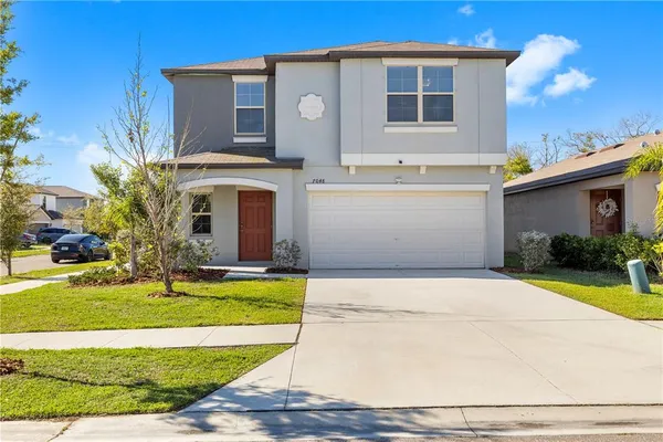 a front view of a house with a yard and garage