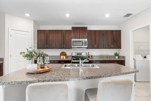 an empty room with a chandelier fan and windows