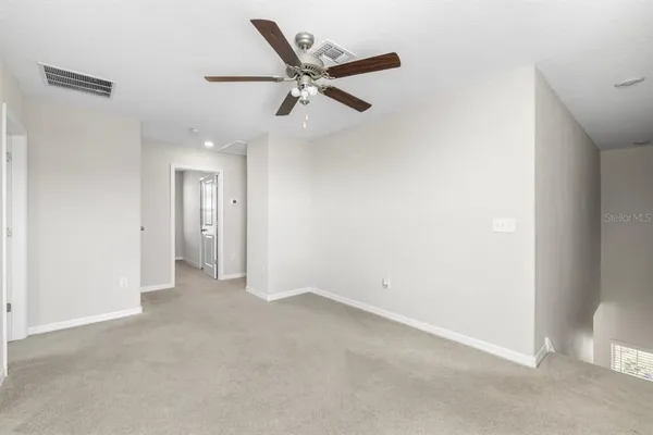 an empty room with a window and a ceiling fan