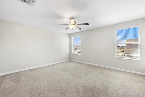 a bathroom with a granite countertop double vanity sink a mirror and a bathtub