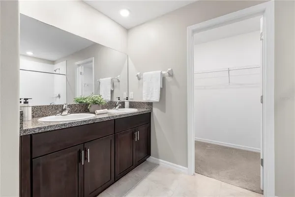 a white bath tub sitting next to a white toilet and vanity