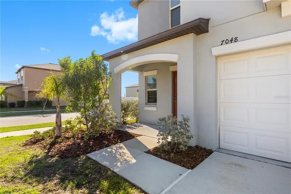 an aerial view of residential houses with outdoor space and lake view in back
