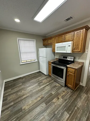 a kitchen with a refrigerator and a stove top oven