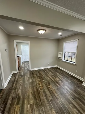 a view of a room with wooden floor and window