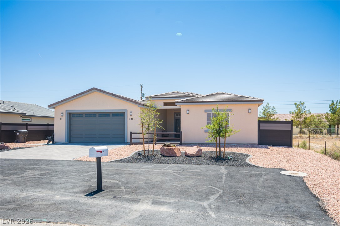 441 Belville Road Pahrump, NV 89048 - Photo 2 of 44 A well-maintained facade with an attached garage and desert-friendly landscaping beckons.